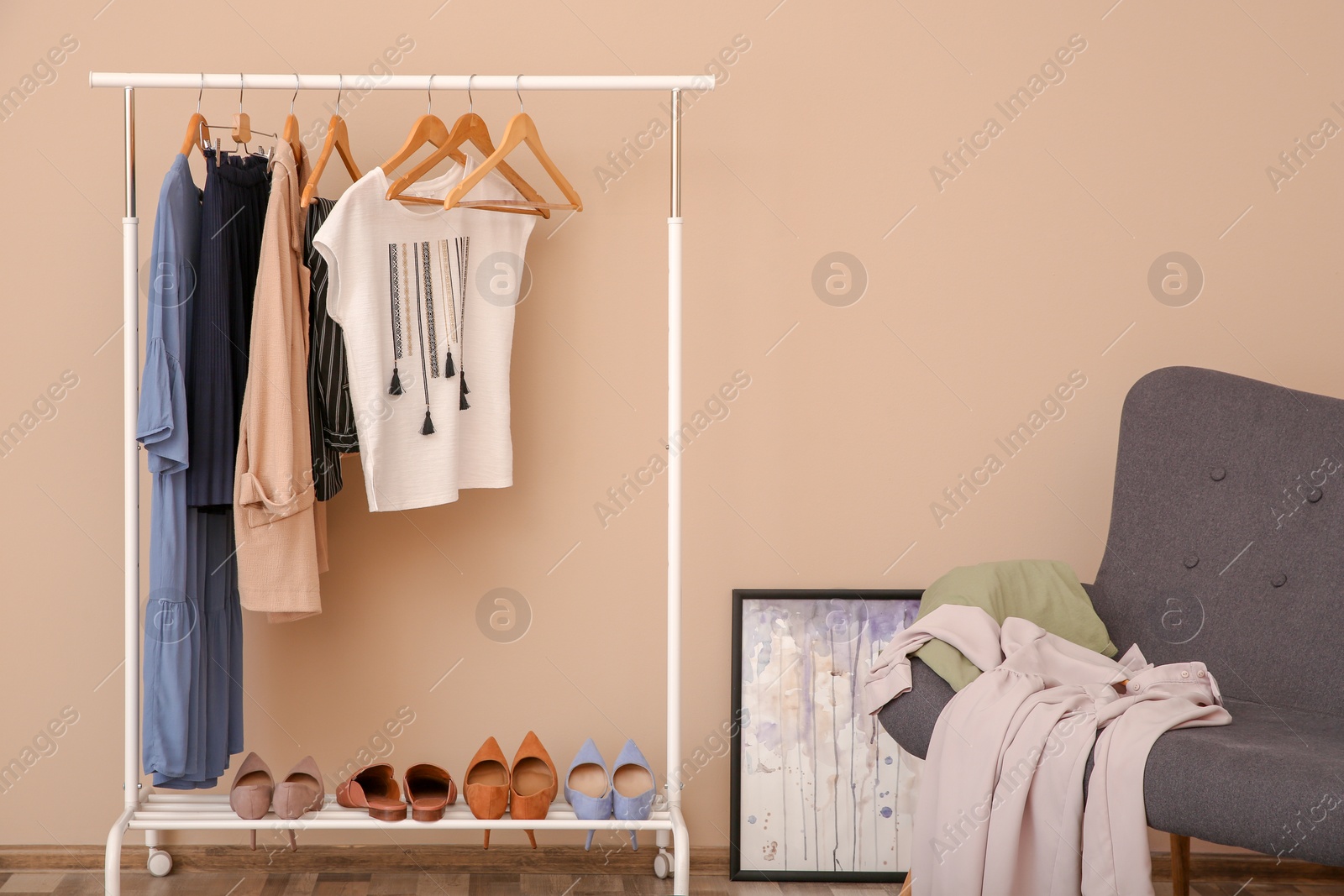 Photo of Wardrobe rack with female clothes in stylish dressing room