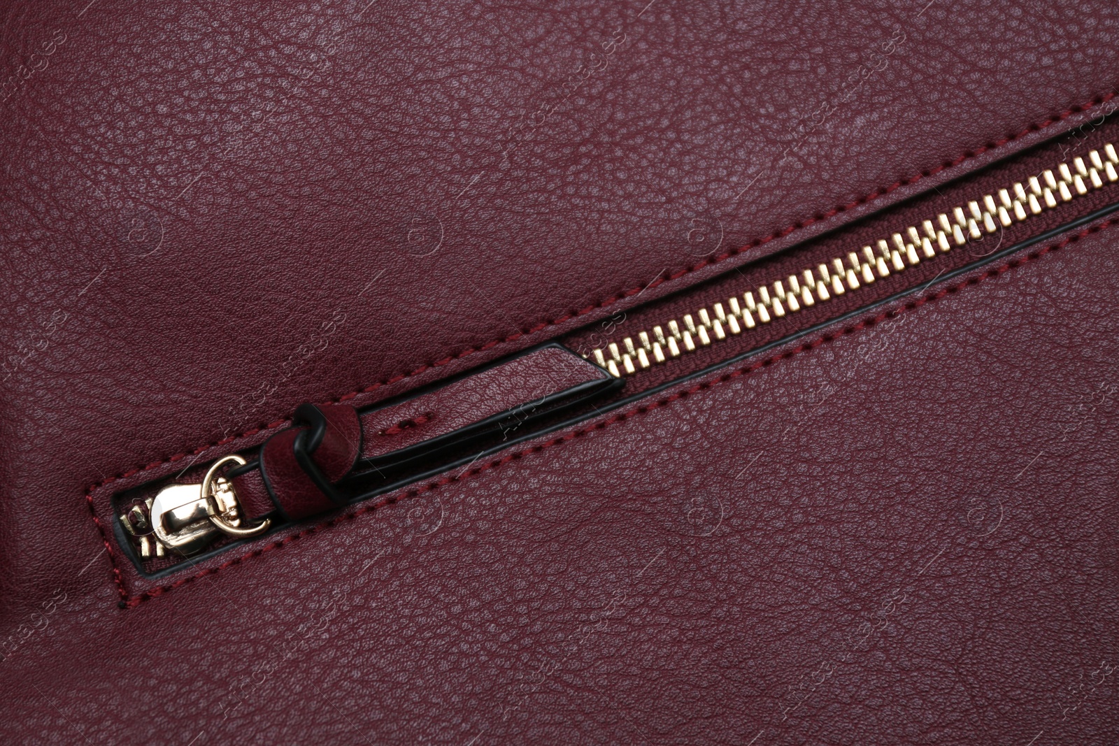 Photo of Burgundy leather fabric with zipper as background, top view