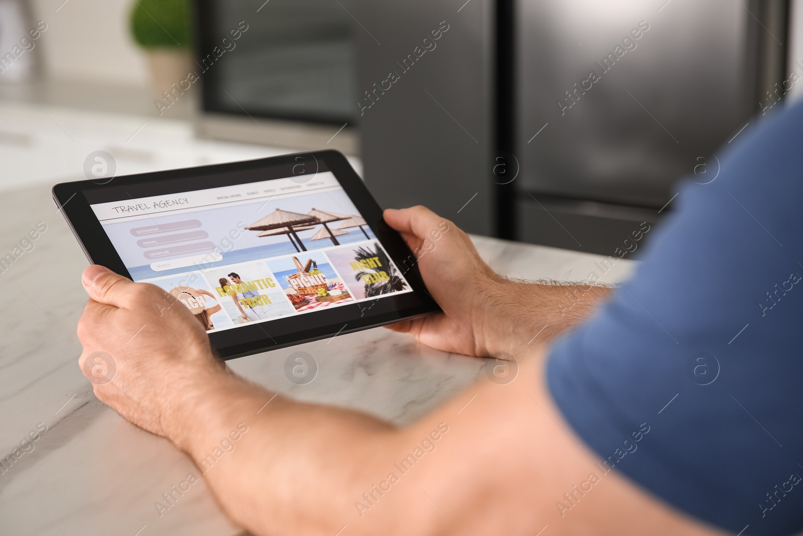 Photo of Man booking tickets online on tablet at table, closeup. Travel agency concept