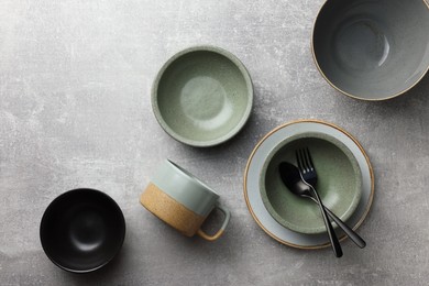 Photo of Stylish empty dishware and cutlery on light grey table, flat lay