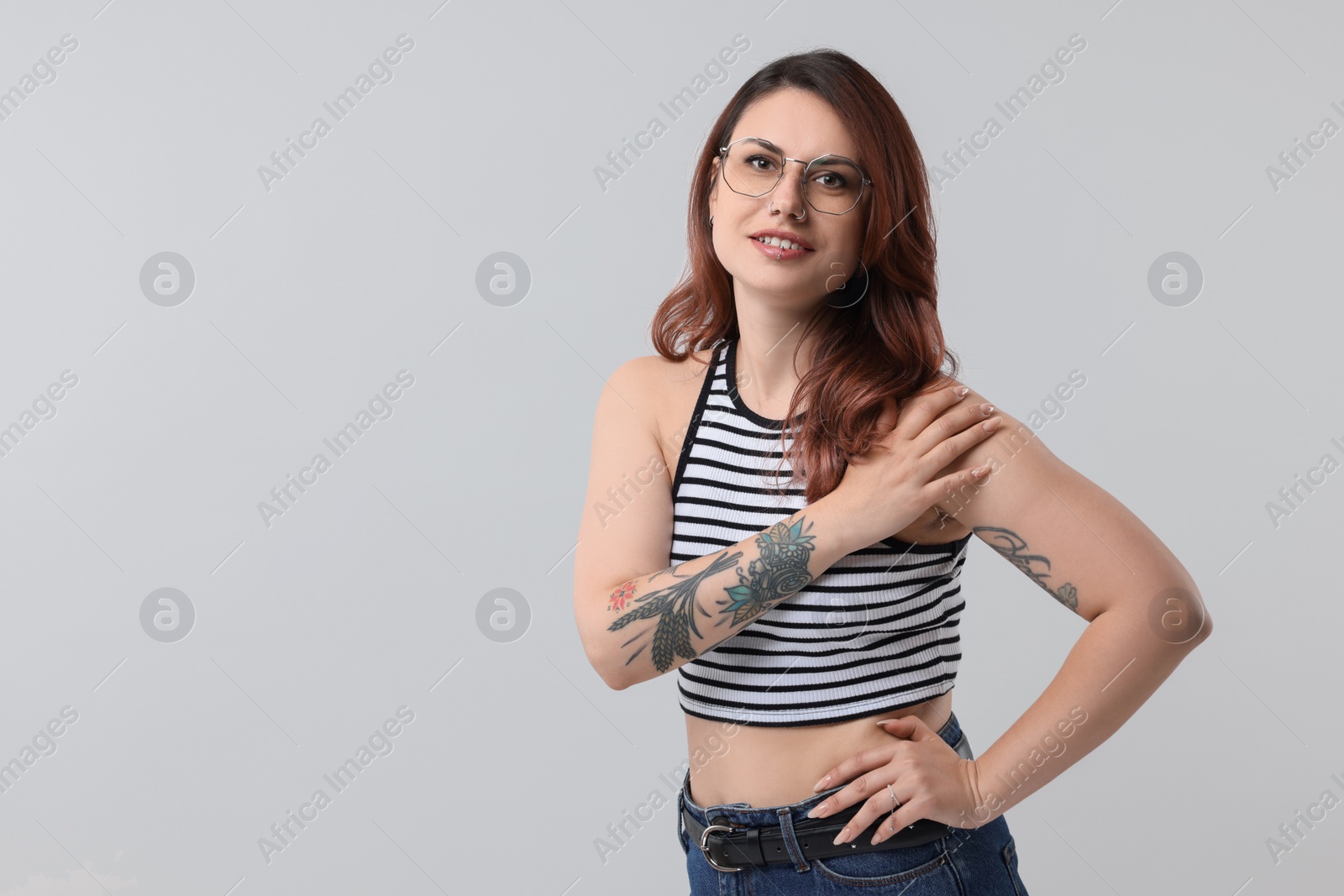 Photo of Beautiful tattooed woman on gray background, space for text