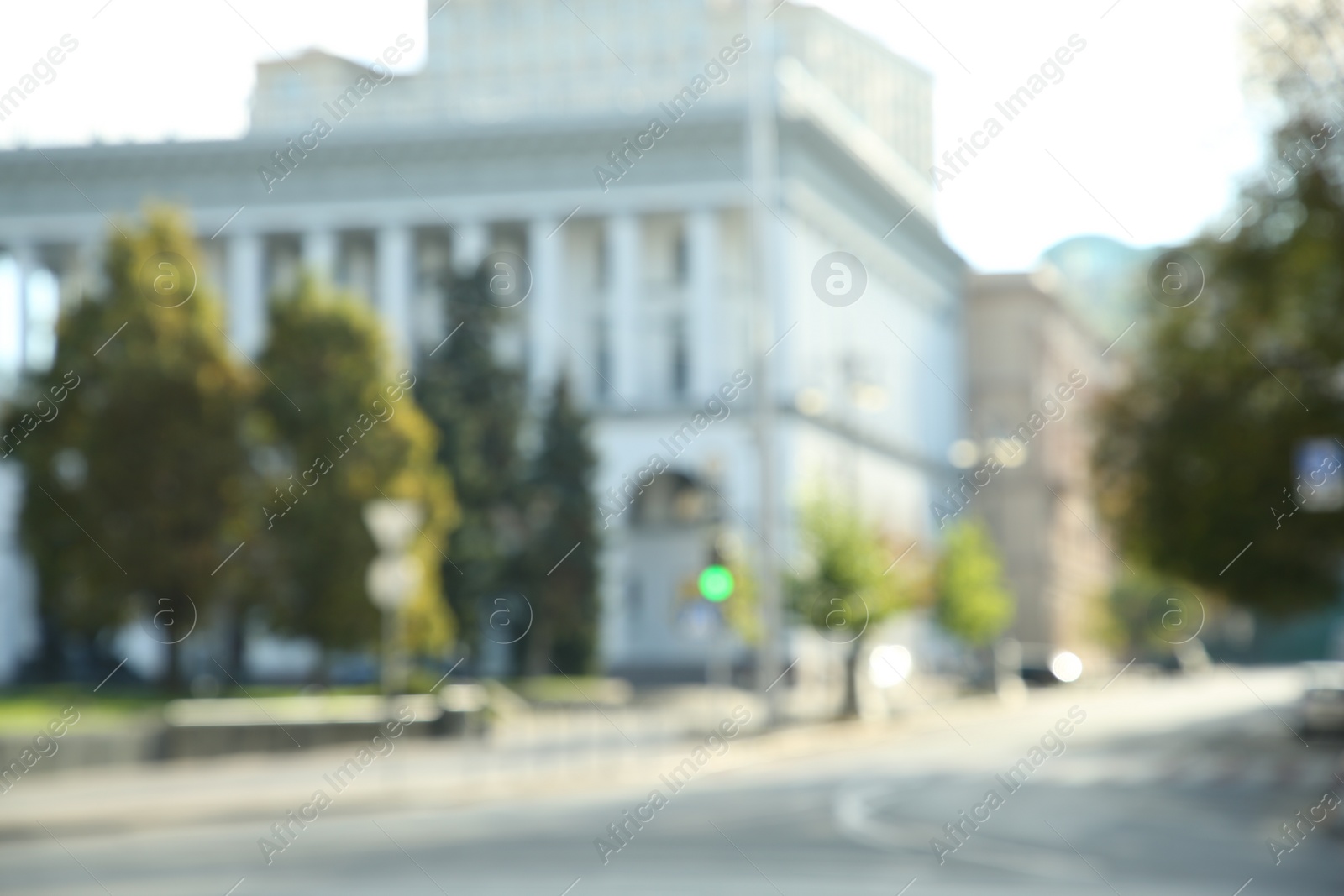 Photo of Blurred view of quiet city street empty road on sunny day