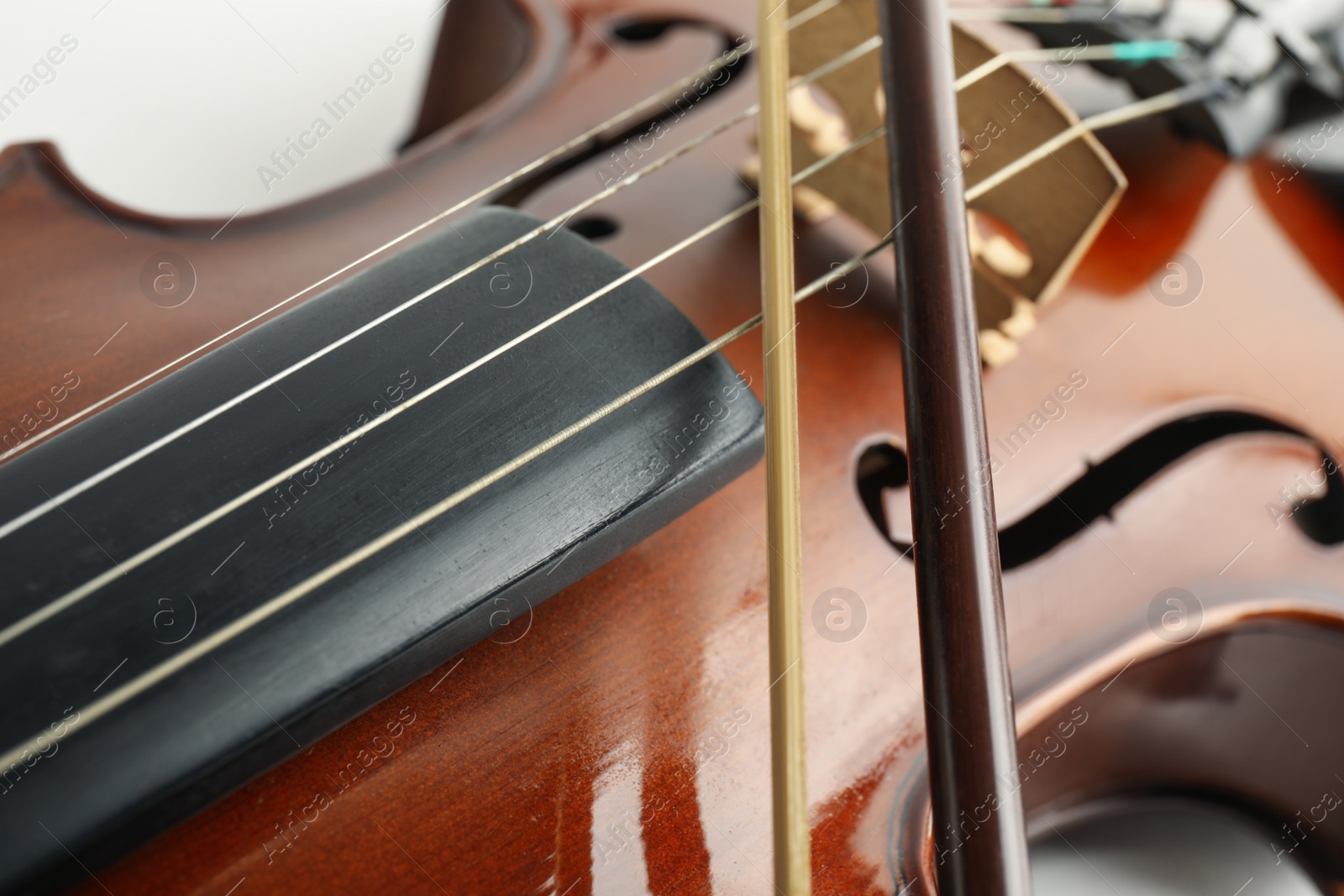 Photo of Beautiful classic violin and bow, closeup view. Musical instrument