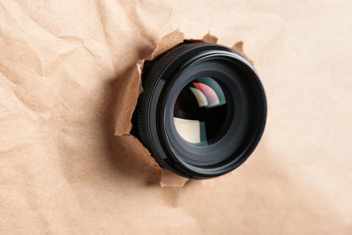 Photo of Hidden camera lens through torn in paper, closeup