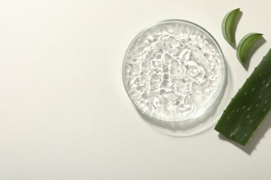 Cosmetic gel and aloe on white background, flat lay. Space for text