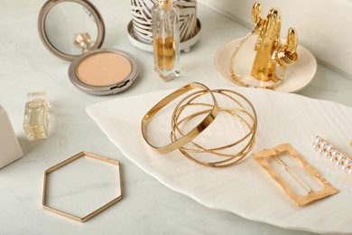 Photo of Stylish golden bijouterie on white marble table