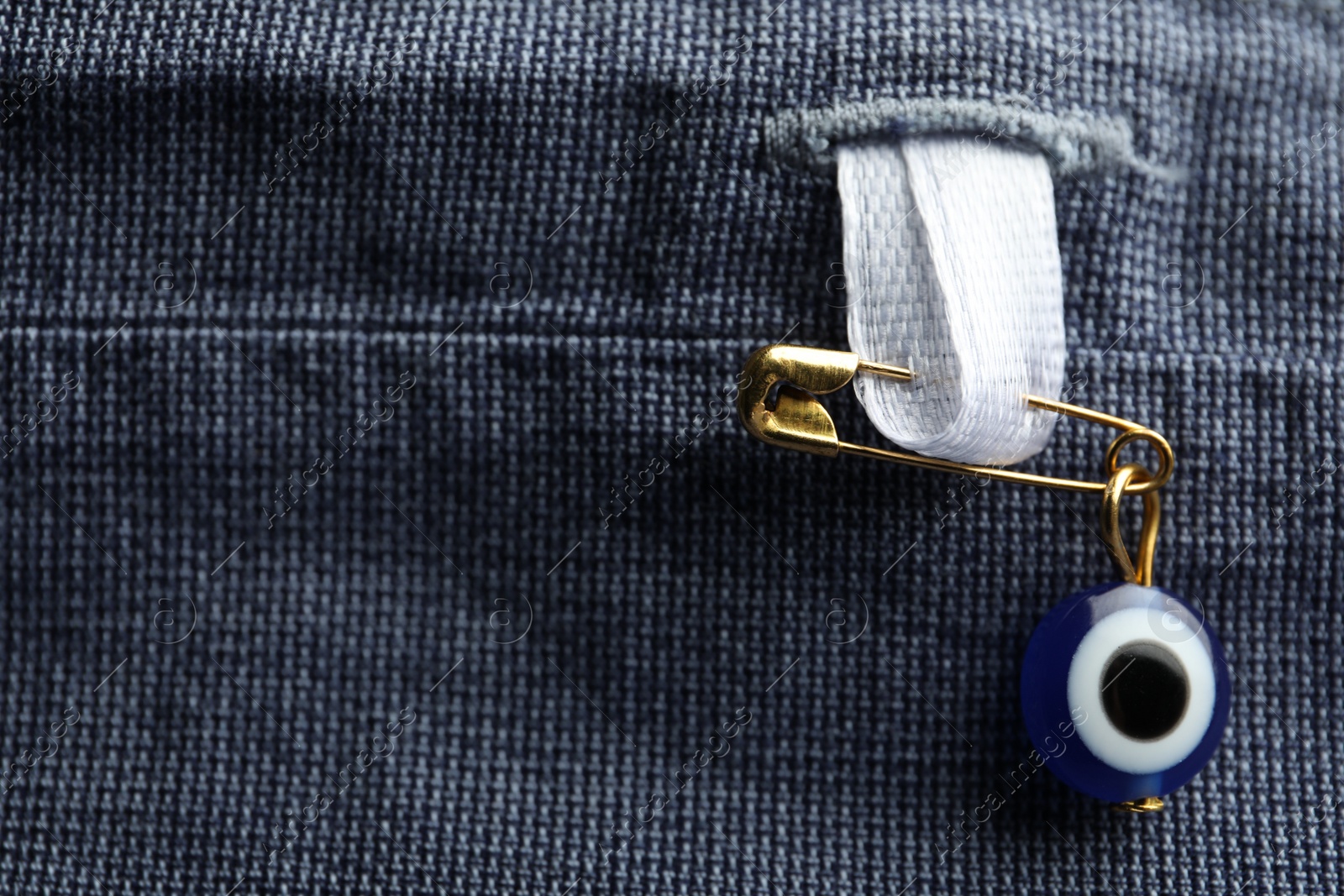 Photo of Evil eye safety pin on clothing, closeup