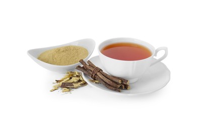 Photo of Aromatic licorice tea in cup, dried sticks of licorice root and powder on white background