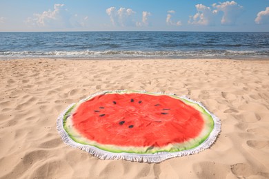 Photo of Beautiful watermelon beach towel with tassels on sandy seashore