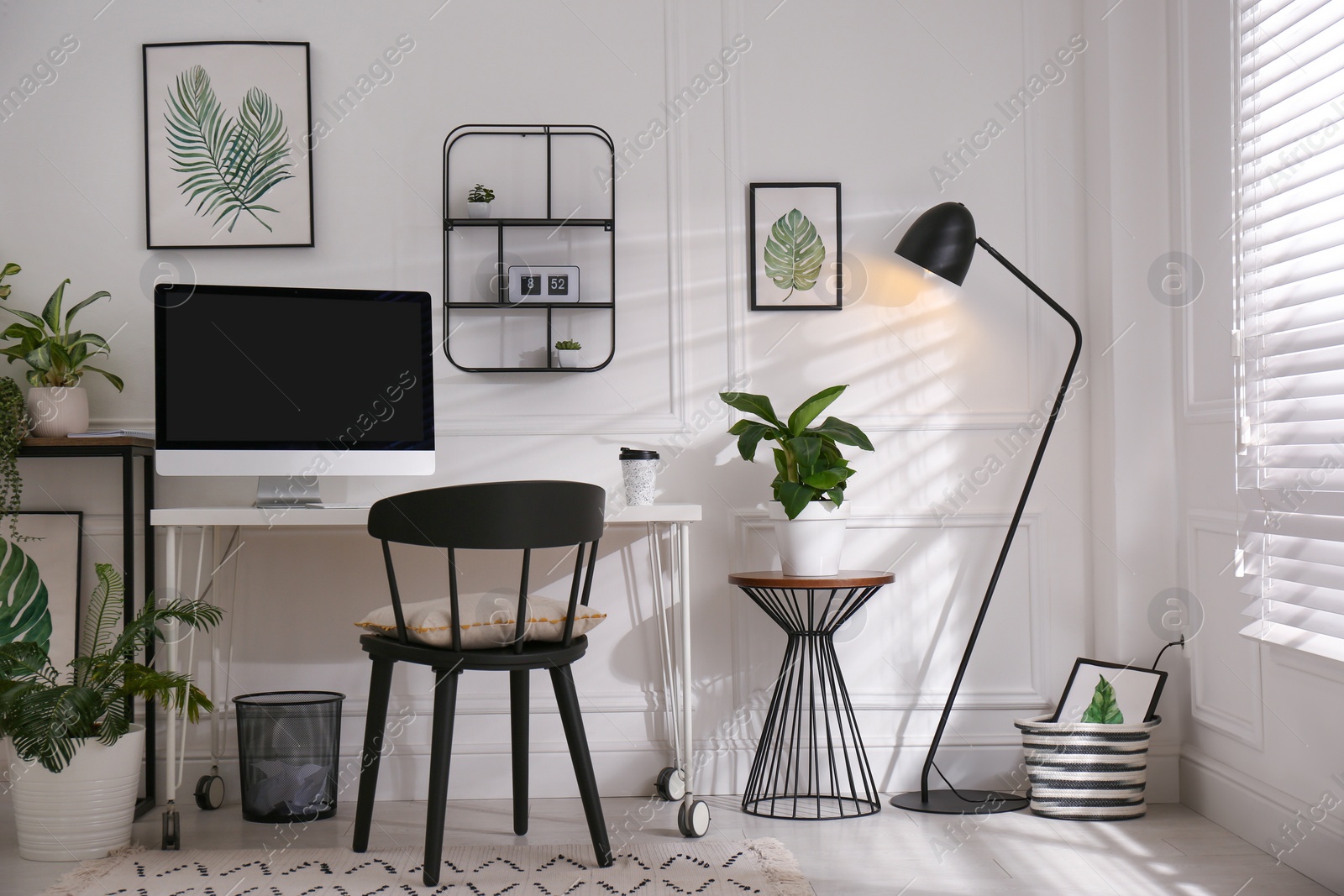 Photo of Comfortable workplace with modern computer and houseplants in room. Interior design