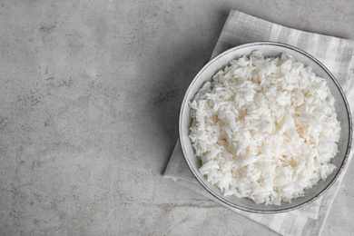 Photo of Bowl with tasty cooked rice on light grey table, flat lay. Space for text