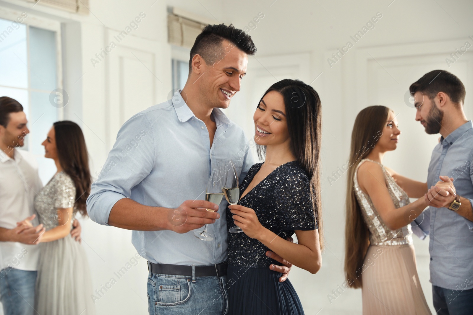 Photo of Lovely young couple with glasses of champagne at dancing party