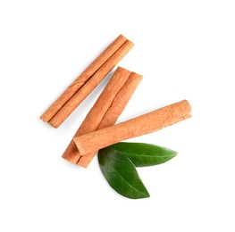 Cinnamon sticks and green leaves isolated on white, top view