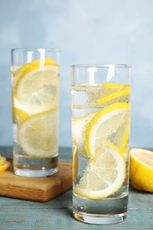 Soda water with lemon slices on blue wooden table