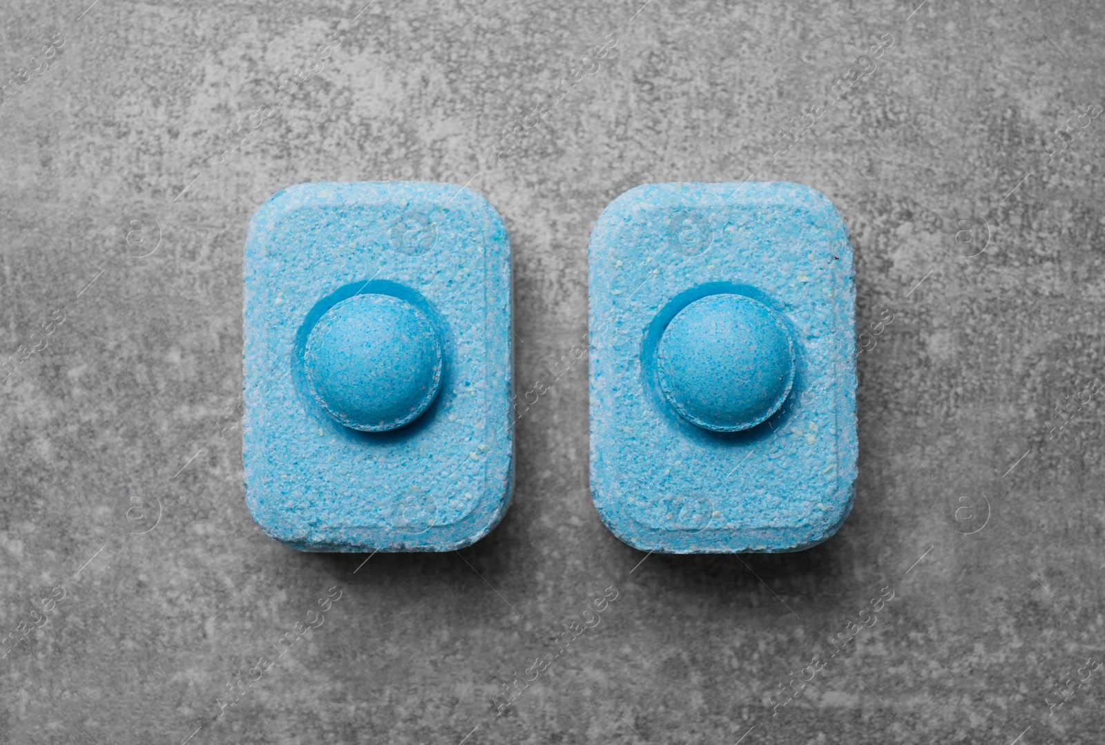 Photo of Water softener tablets on grey table, flat lay