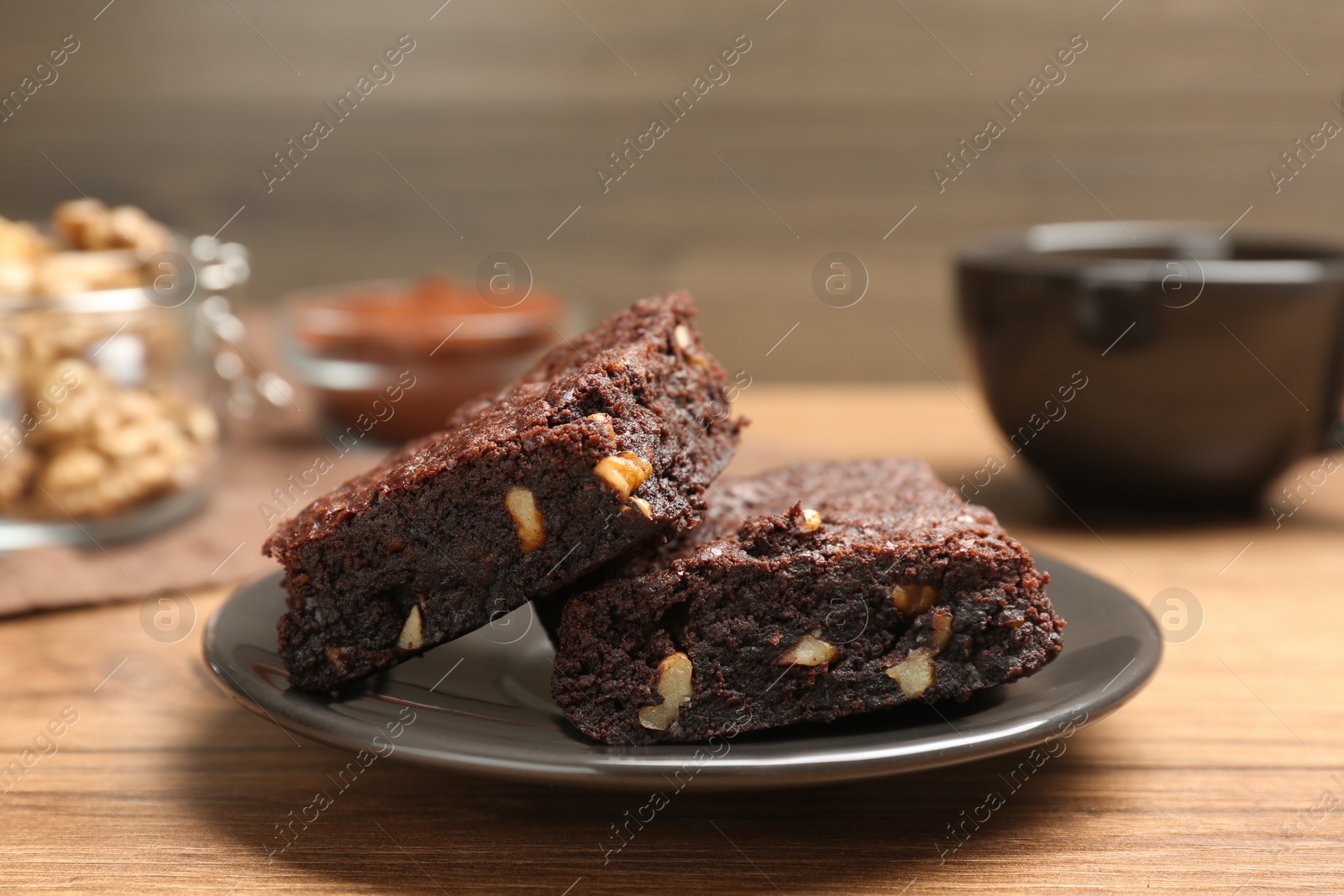 Photo of Delicious chocolate brownies with nuts on wooden table, closeup