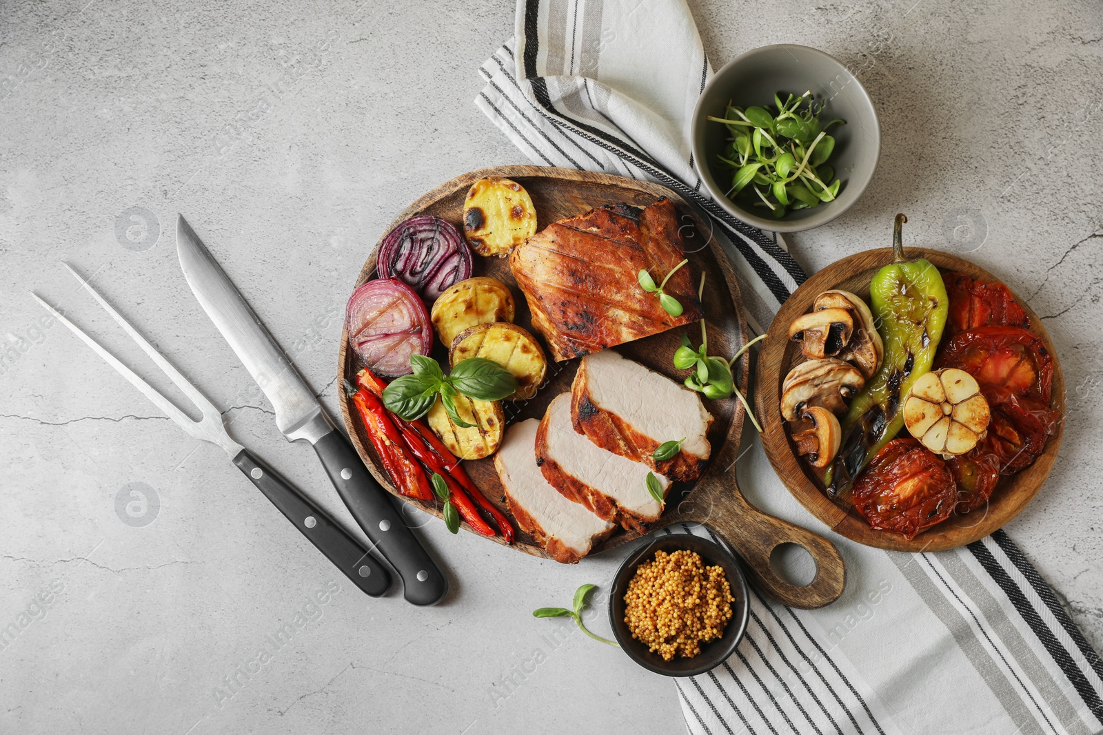 Photo of Delicious grilled meat and vegetables served on light grey table, flat lay