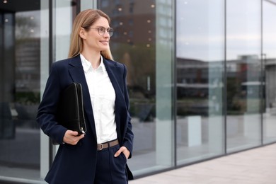 Photo of Real estate agent with leather portfolio outdoors. Space for text