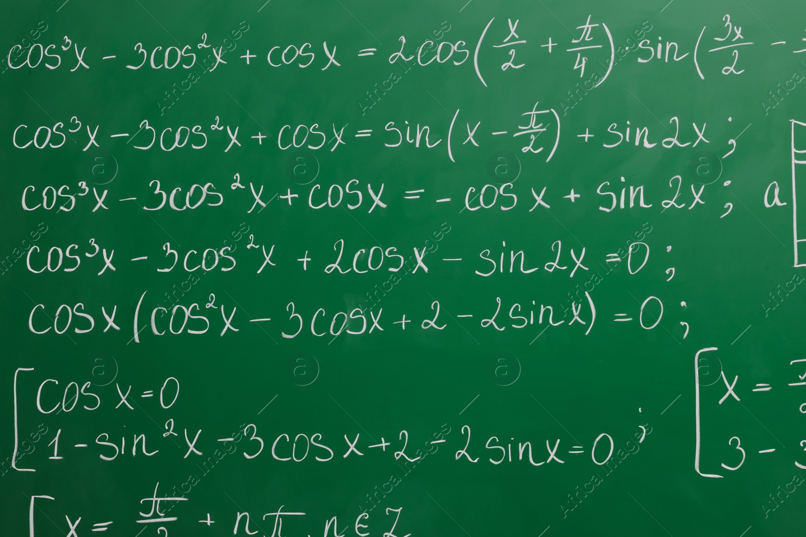 Photo of Many different math formulas written on green chalkboard