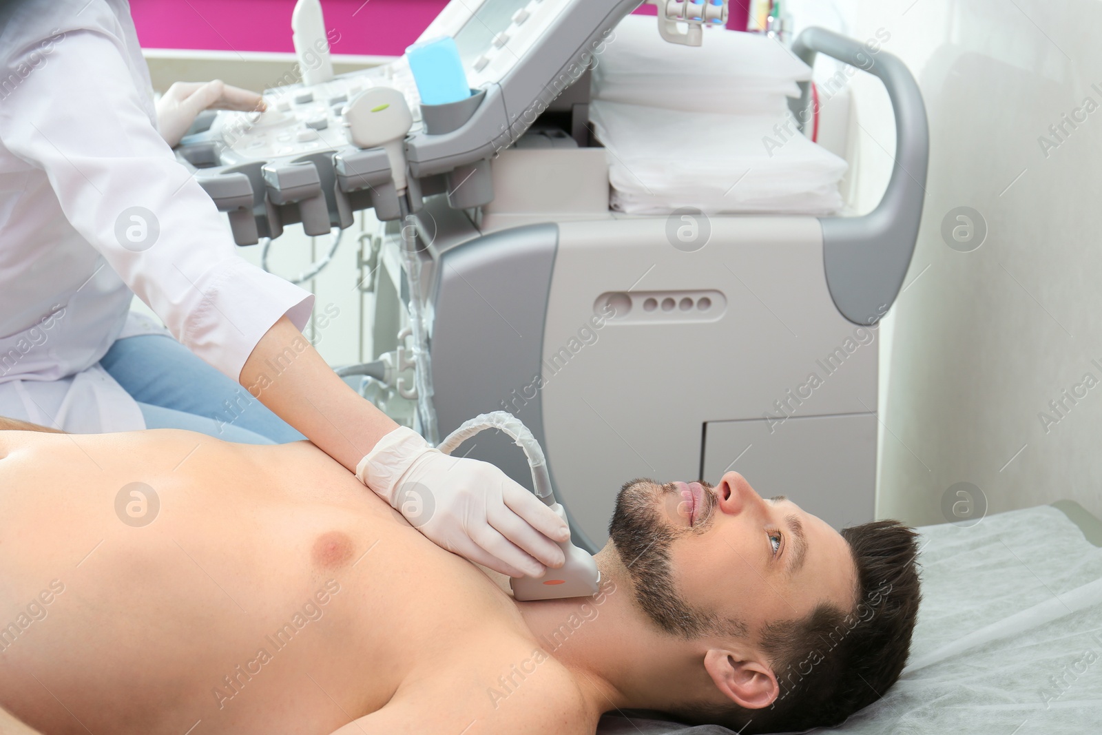 Photo of Doctor conducting ultrasound examination of thyroid gland in clinic