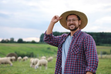 Portrait of smiling man on pasture at farm. Space for text