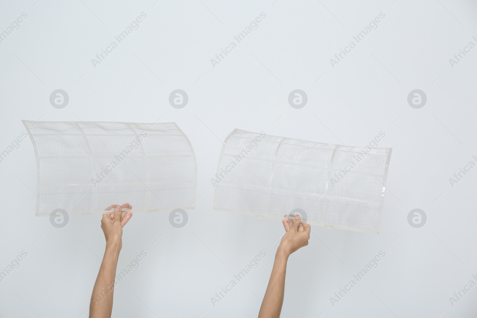 Photo of Woman holding air conditioner filters near white wall, closeup