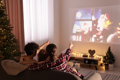 Photo of Family watching Christmas movie via video projector at home