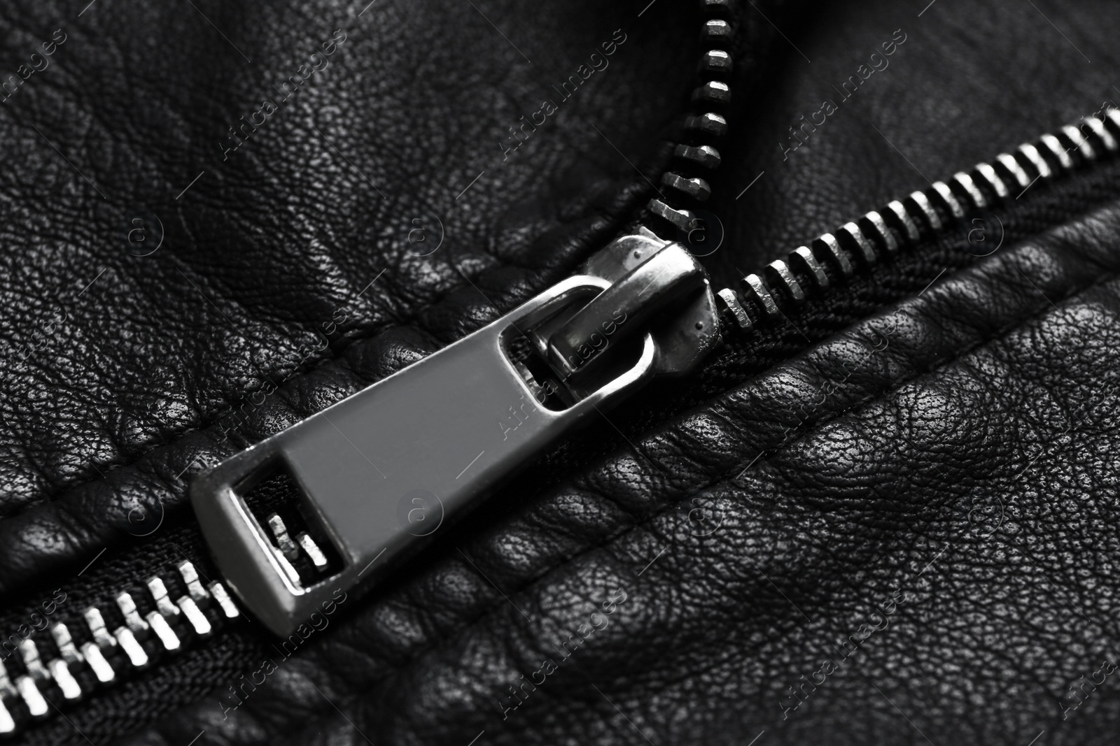 Photo of Closeup view of black leather jacket with zipper as background