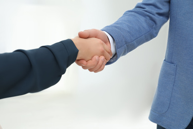 Real estate agent shaking hands with client in new apartment, closeup