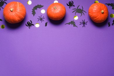 Photo of Flat lay composition with pumpkins, paper bats and spiders on purple background, space for text. Halloween decor