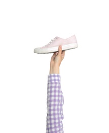 Photo of Young woman holding comfortable shoe on white background, closeup