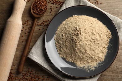 Photo of Flat lay composition with buckwheat flour and grains on wooden table