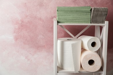 Photo of Shelving unit with paper towels near pink wall. Space for text