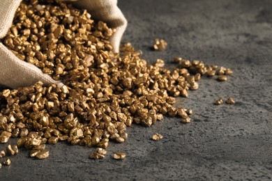 Photo of Overturned sack of gold nuggets on grey table