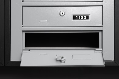 Photo of Open empty grey metal mailbox with keyhole indoors