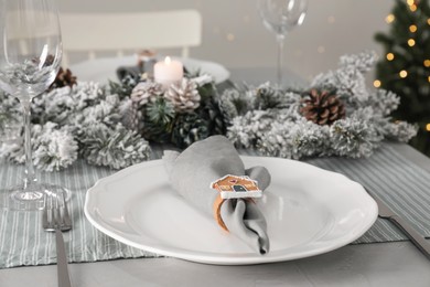 Photo of Festive place setting with beautiful dishware, cutlery and fabric napkin for Christmas dinner on grey table