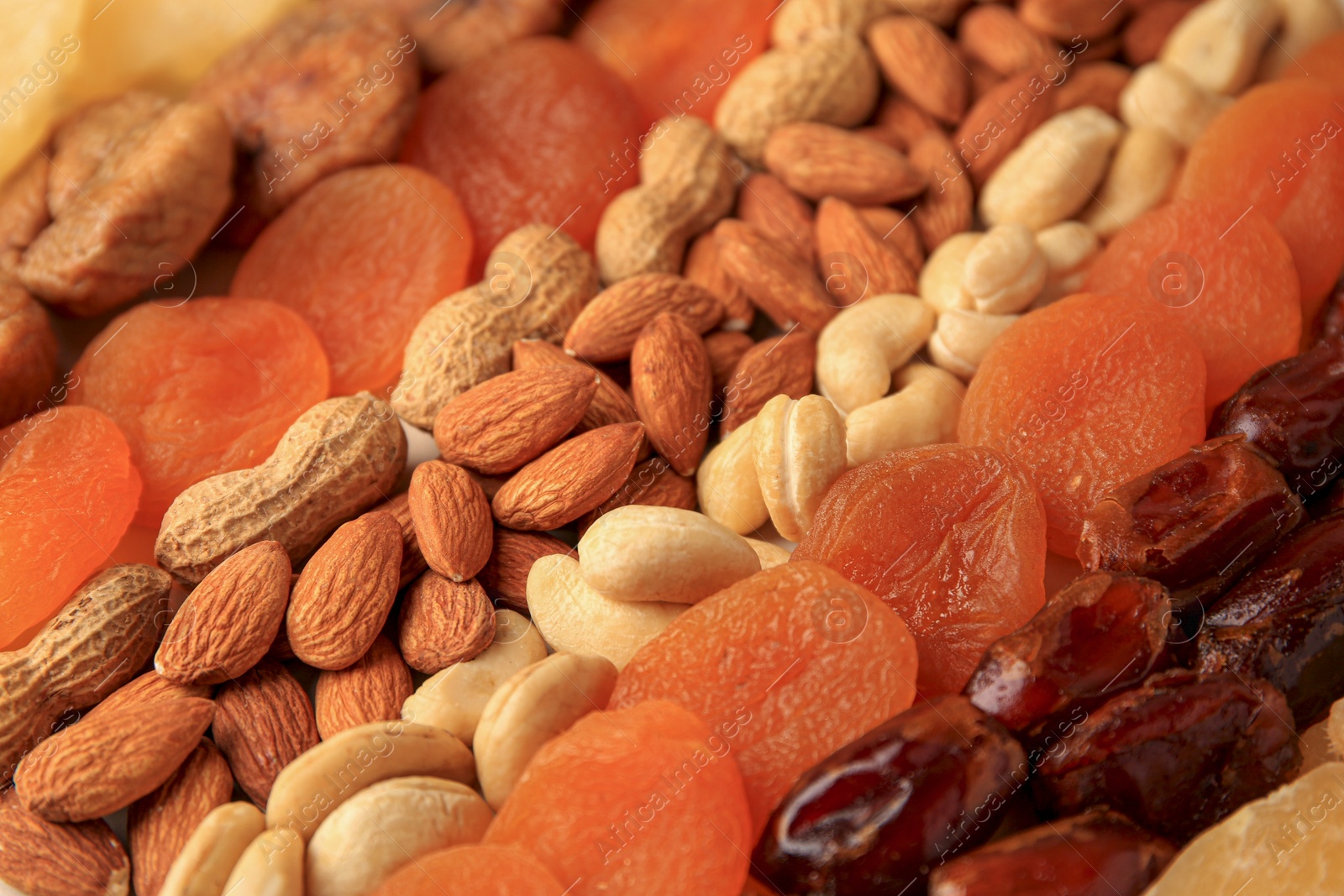 Photo of Different tasty nuts and dried fruits as background, closeup