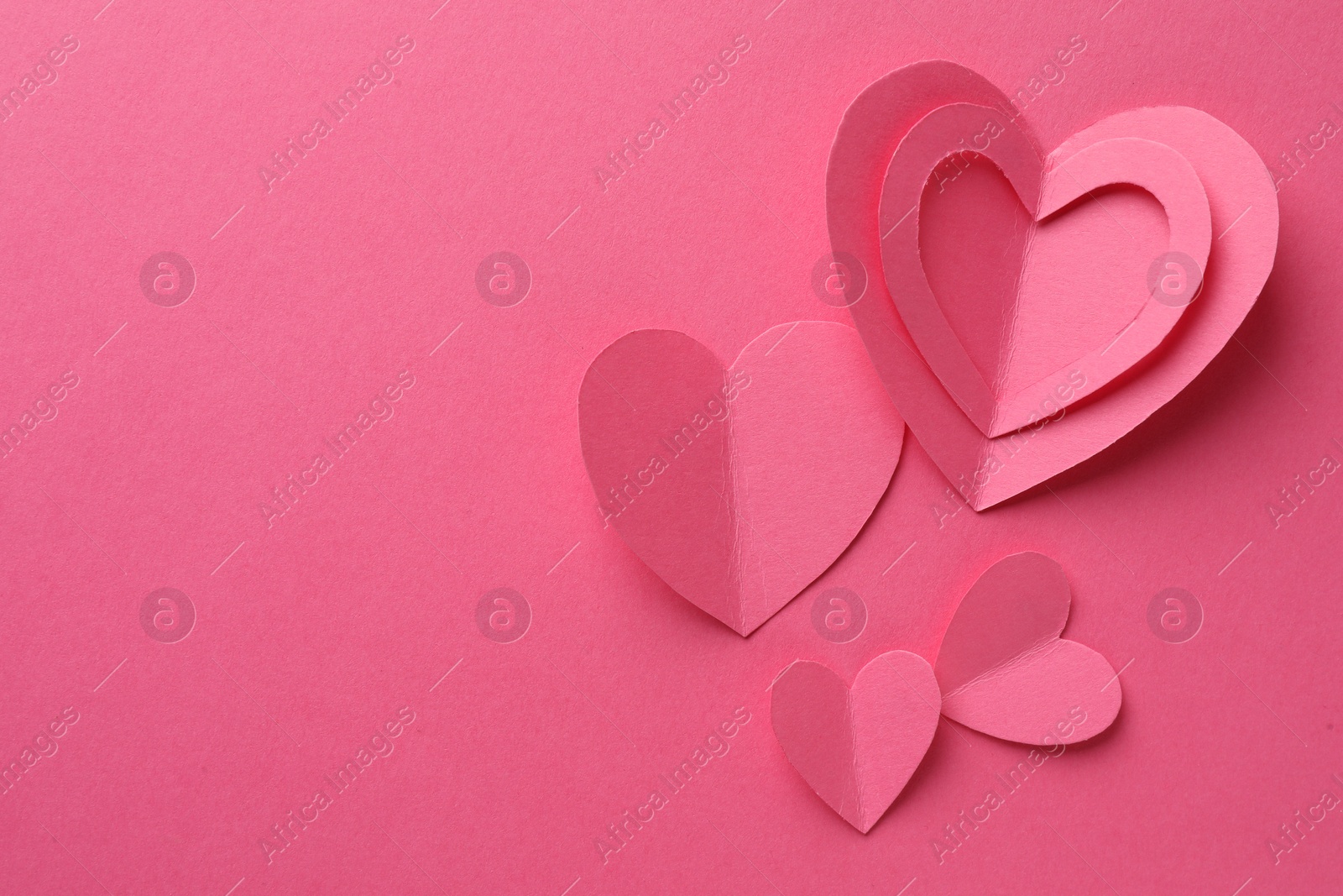 Photo of Paper hearts on pink background, flat lay. Space for text