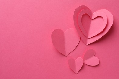 Paper hearts on pink background, flat lay. Space for text