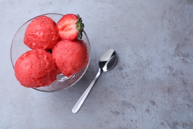 Delicious strawberry ice cream served on grey table, top view. Space for text