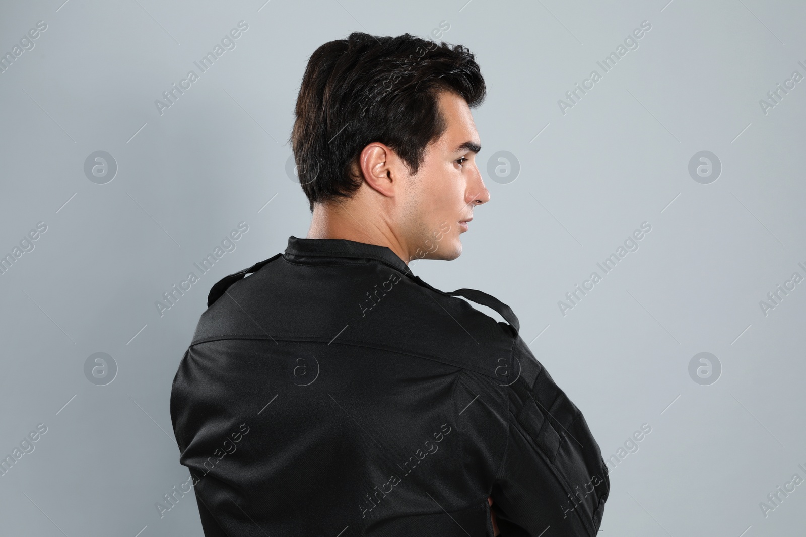 Photo of Male security guard in uniform on grey background