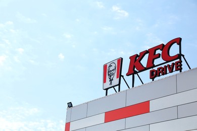 Lviv, Ukraine - May 1, 2022: Modern building with KFC logo against blue sky, low angle view