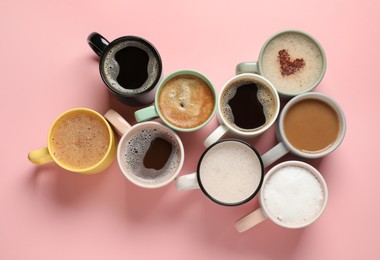 Photo of Many different cups with aromatic coffee on pink table, flat lay
