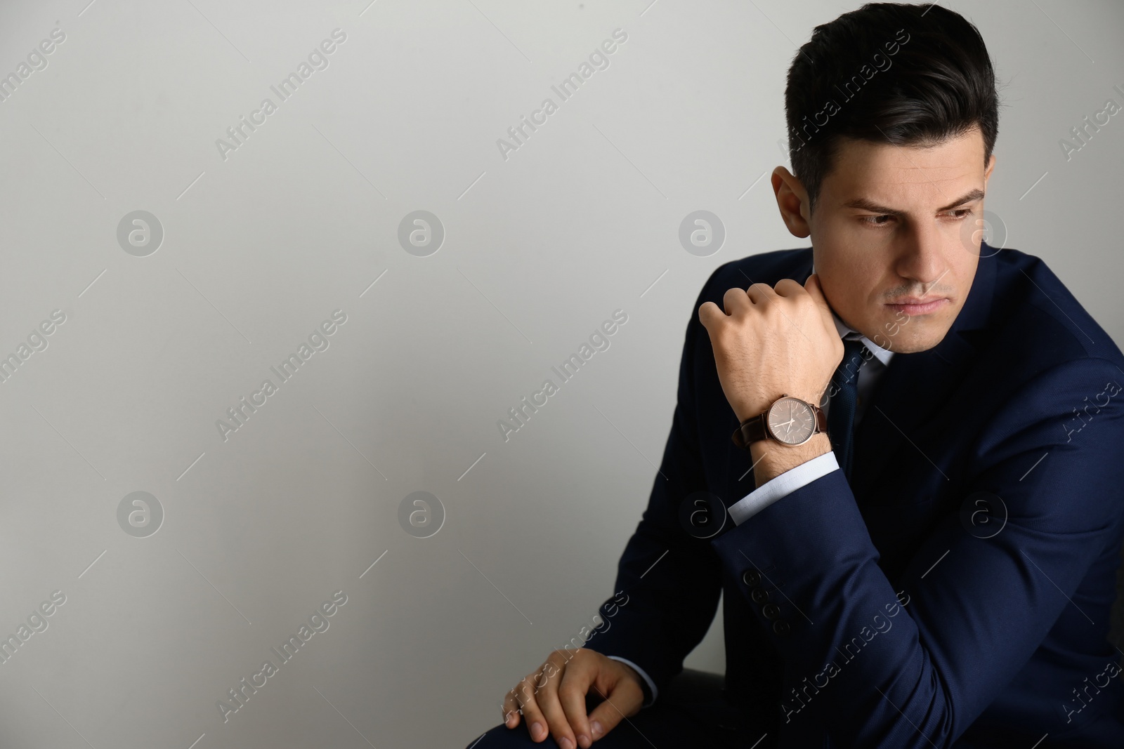 Photo of Businessman with luxury wrist watch on grey background. Space for text