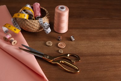 Set of sewing supplies and accessories on wooden table