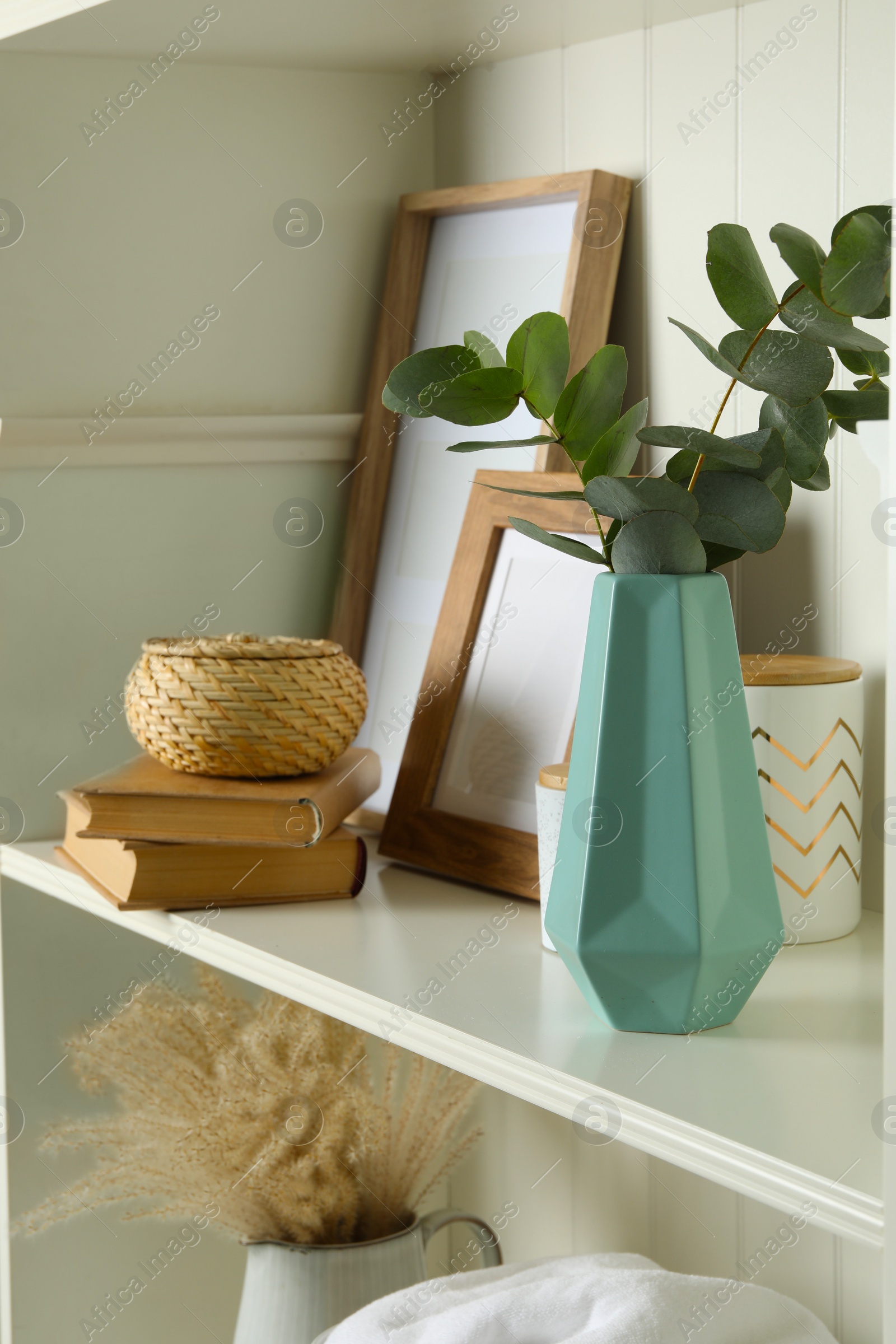 Photo of White shelving unit with different decorative elements