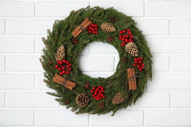 Photo of Beautiful Christmas wreath on white brick wall