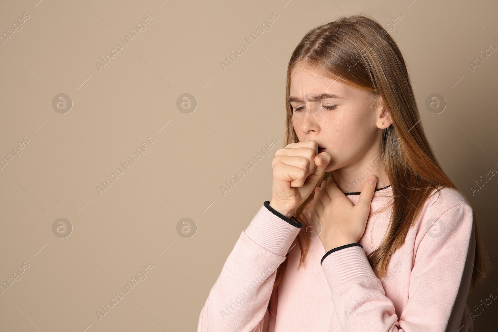 Photo of Teenage girl suffering from cough on color background. Space for text