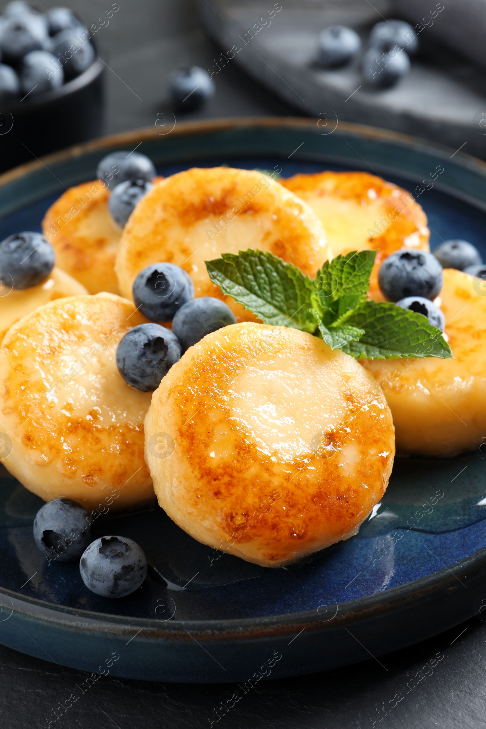 Photo of Delicious cottage cheese pancakes with blueberries on table, closeup