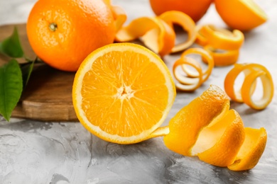 Photo of Orange fruit with peel on light grey table